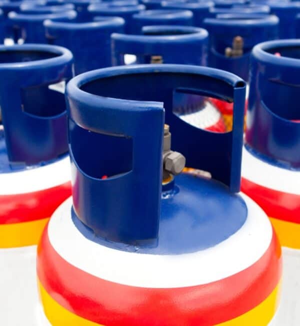 A row of gas tanks with rainbow strips at the top.