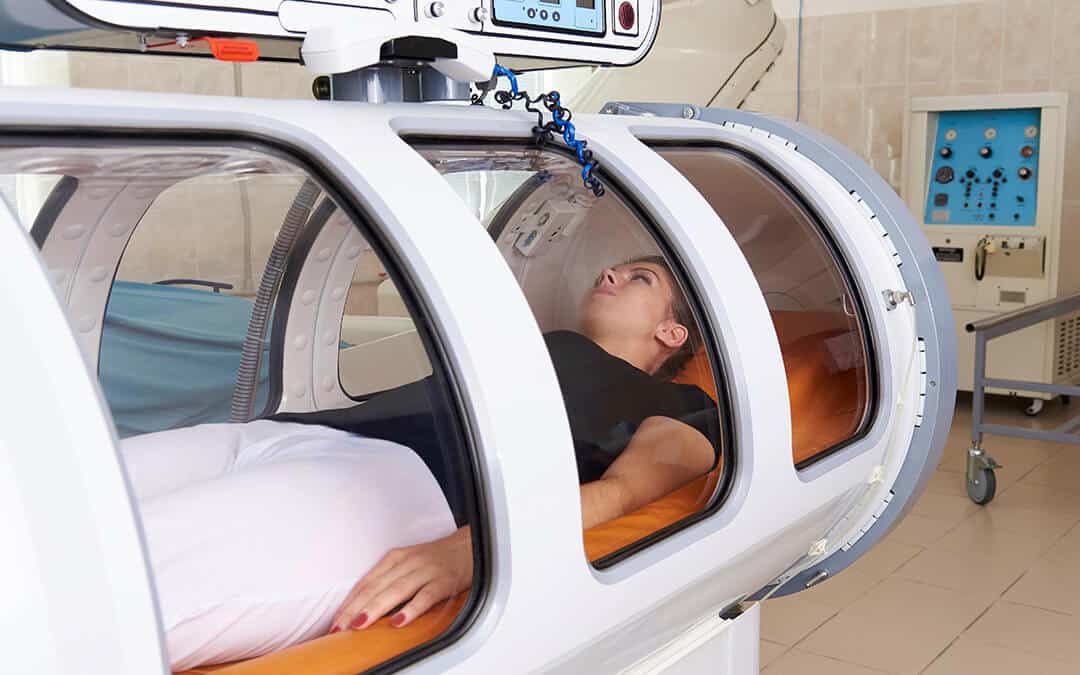 A woman receiving oxygen therapy in a hyperbaric chamber.
