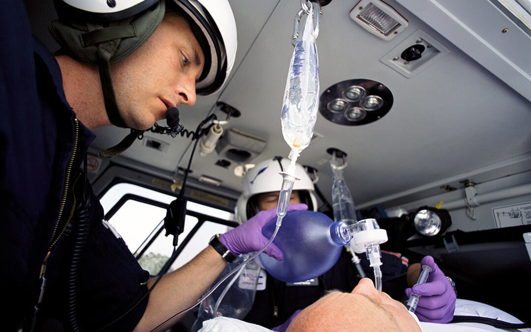 A low angle closeup of paramedics tending to a patient on an emergency airlift helicopter.