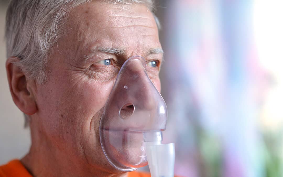 Close-up of an elderly man doing inhalation