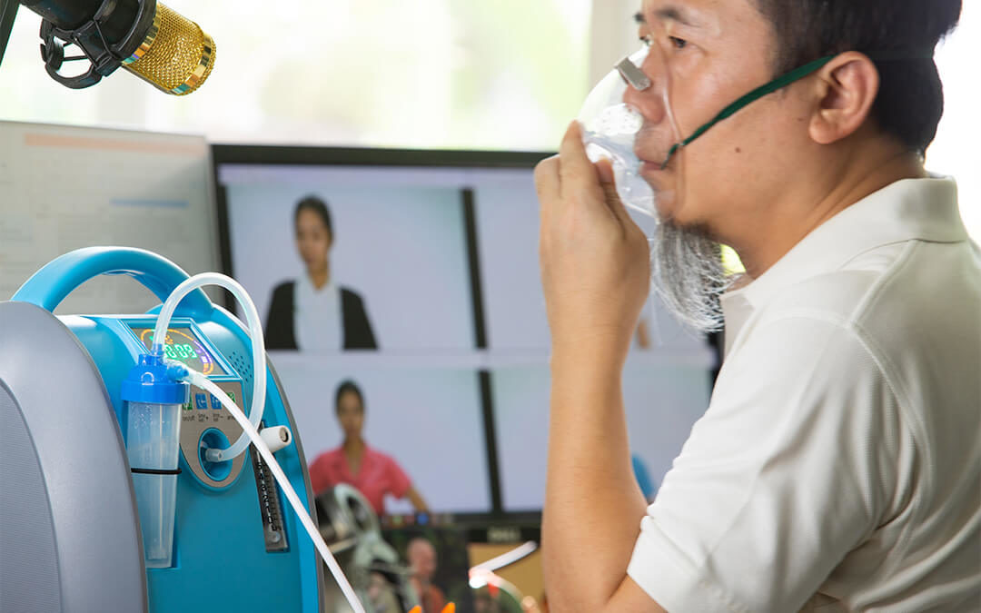 Older man wearing an inhaler oxygen mask in a video conference meeting with many employees.