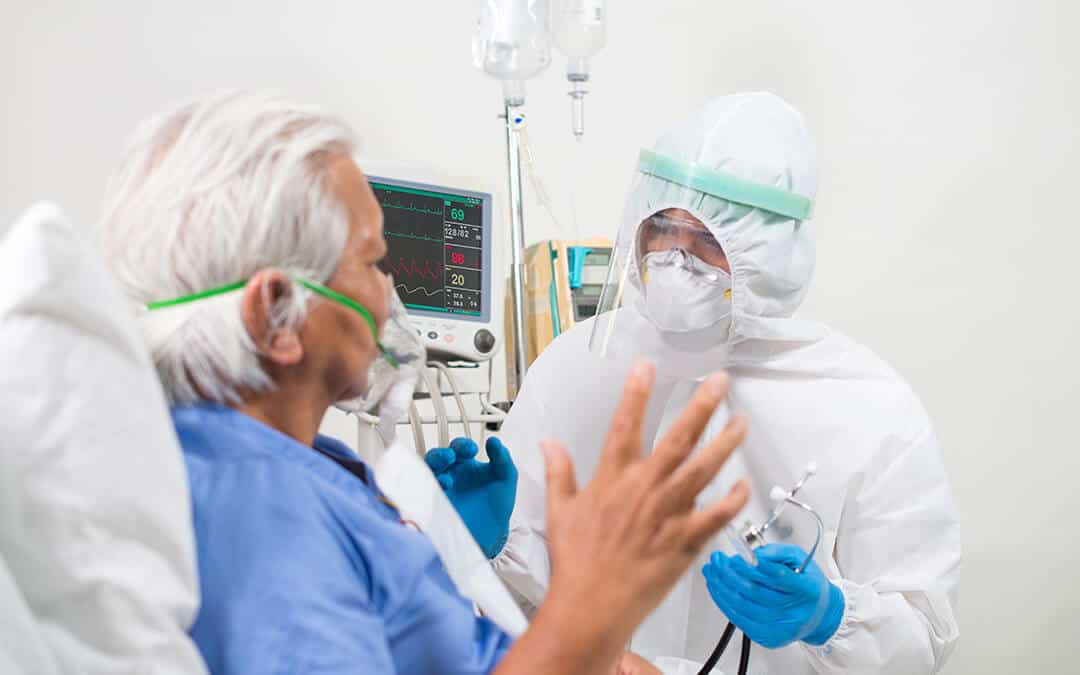 Doctor treating patient infected with Covid-19 in an ICU room.