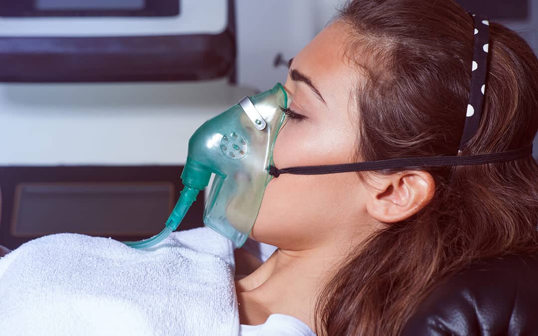 Young woman with oxygen mask at hospital or cosmetics salon 
