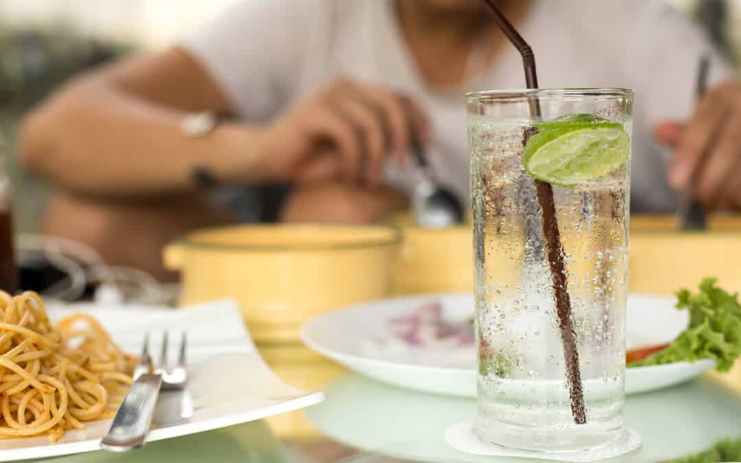 Man having glass of fresh sparkling mineral water with his dinner