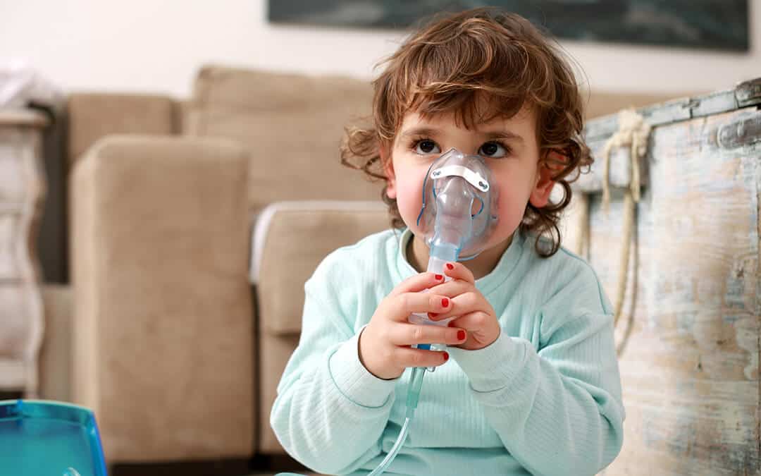 Little girl using inhaler at home