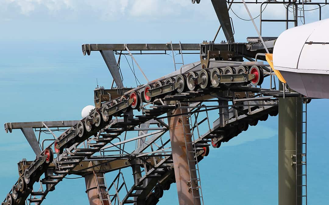 Stack of rollers from cable car track with blue sea in the background