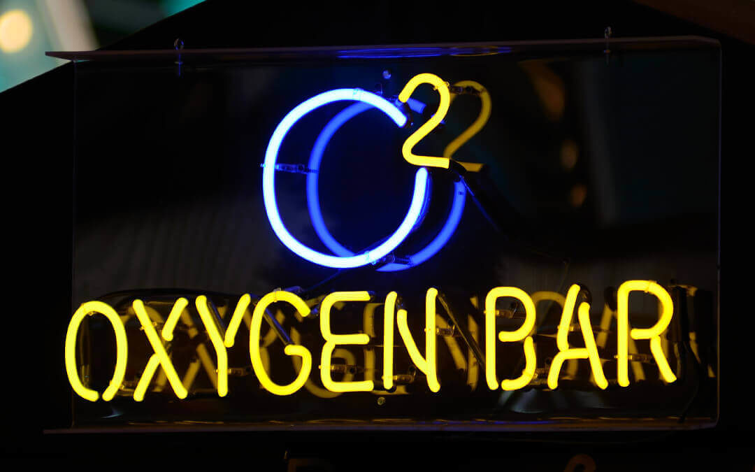 Yellow and blue neon sign that says "Oxygen Bar"