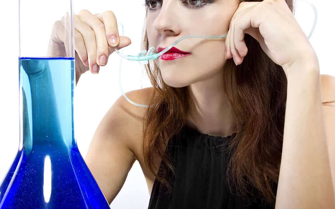 Woman at oxygen bar about to put a cannula (nose tubes) into her nose