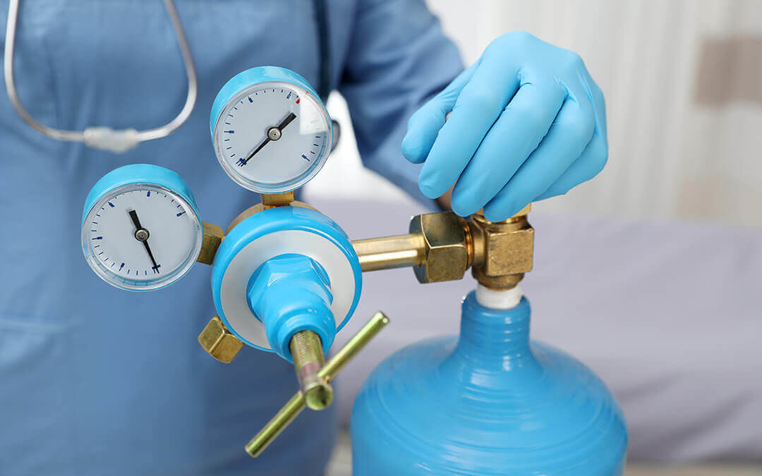 Doctor with blue gloves checking tank of compressed air