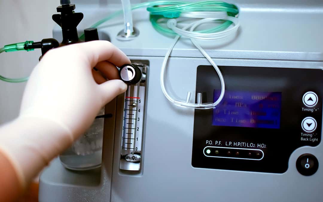 A person's hand changing oxygen levels on a machine