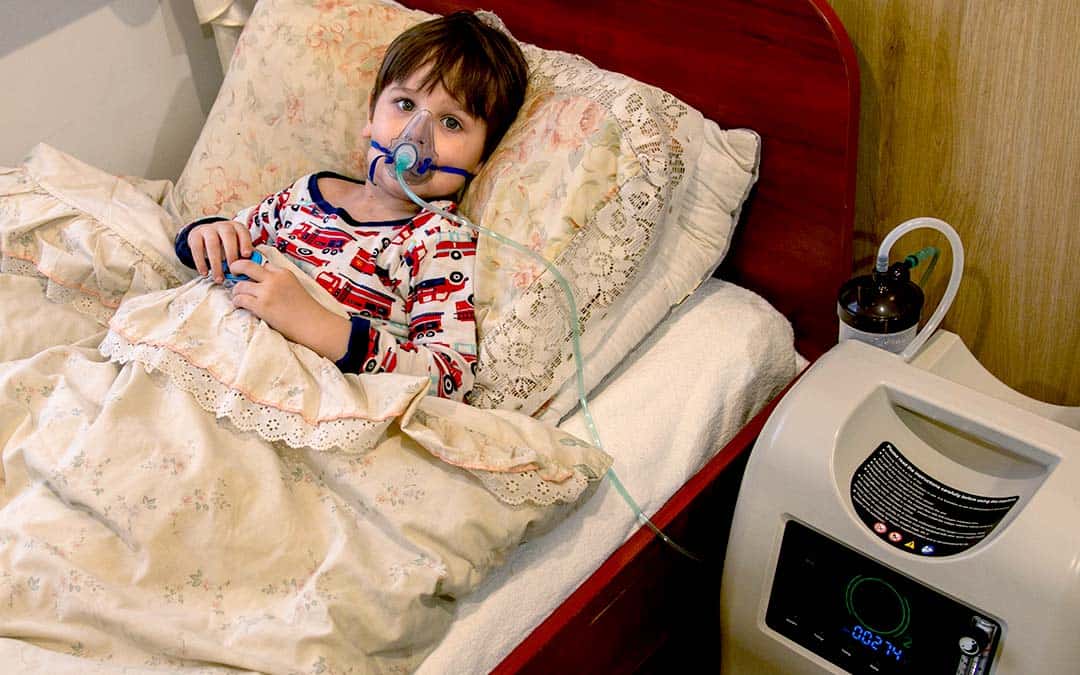Child at home with oxygen tank