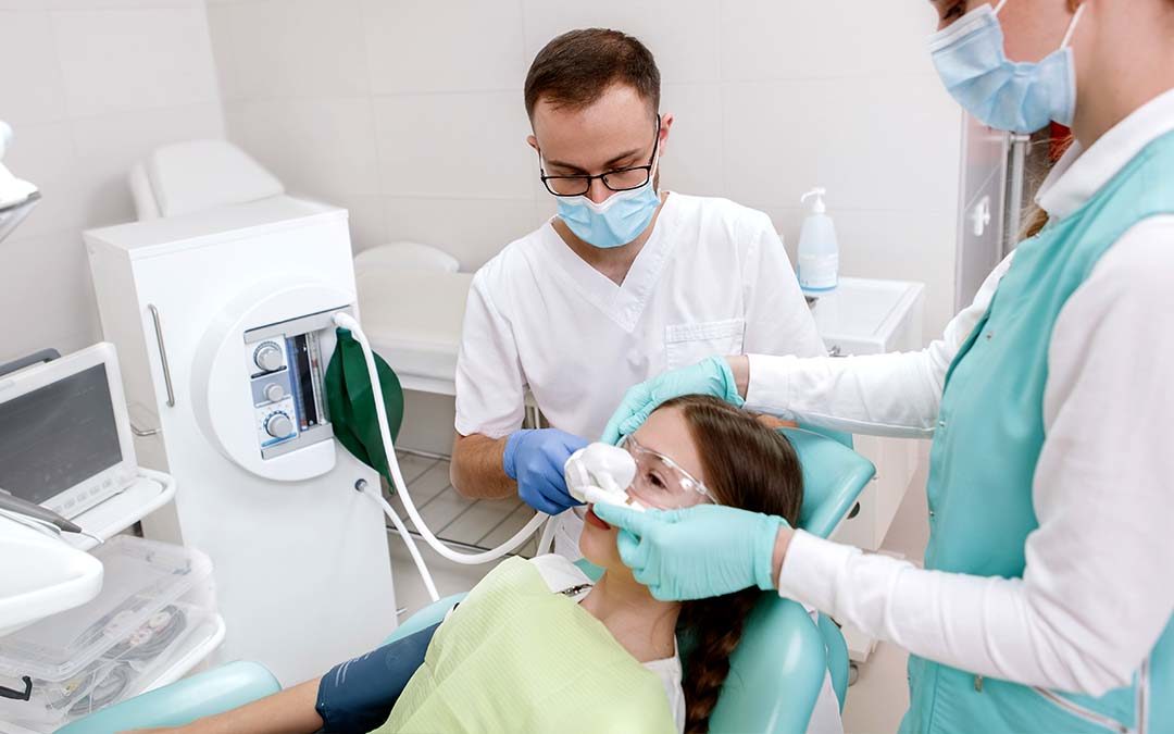 Dentist applying anesthesia to young patient