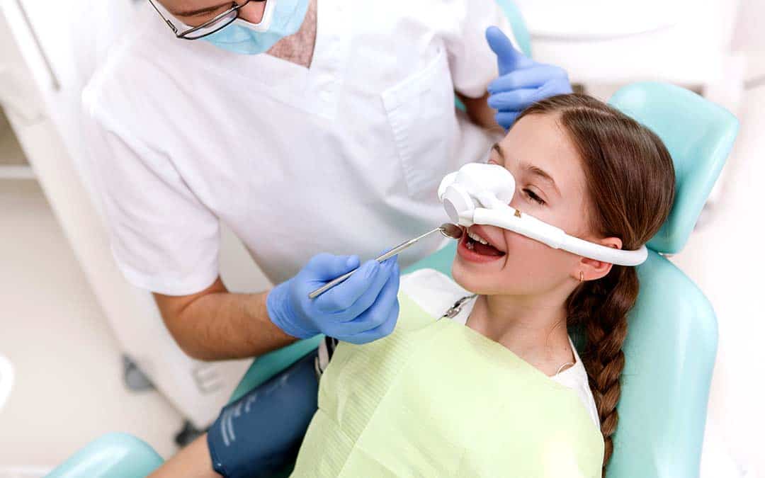 Dentist applying anesthesia to young patient