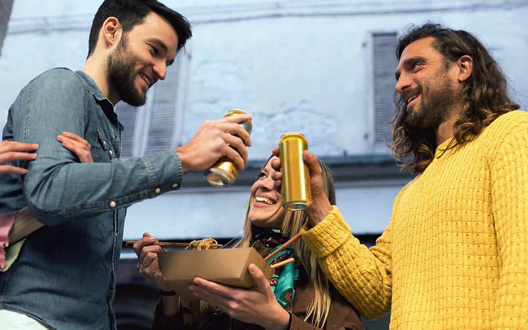 Two men cheering with their hard seltzer cans