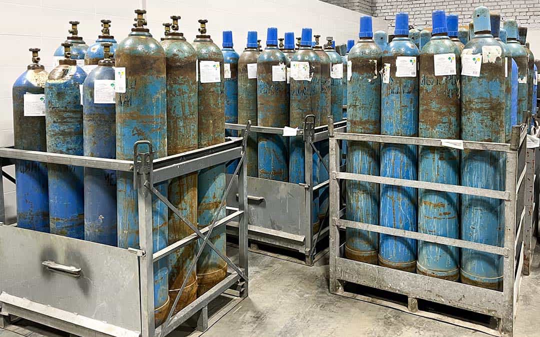 Several racks of many medical gas tanks standing up