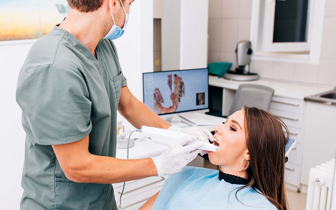 Dental assistant putting a camera device in a patient's mouth