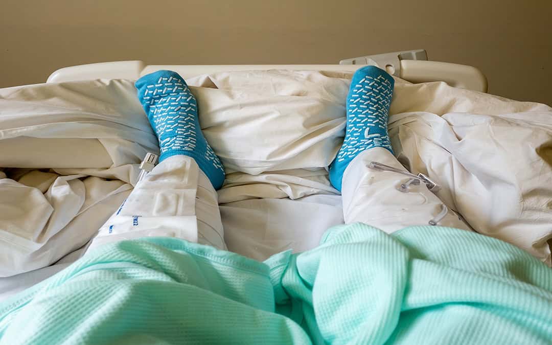 A hospital patient wearing inflatable compression leg presses to prevent blood clots during surgery.