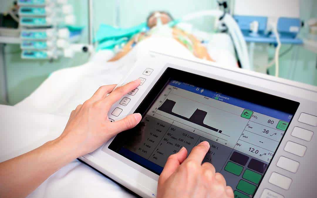 hospital patient in bed with computer monitor device in foreground